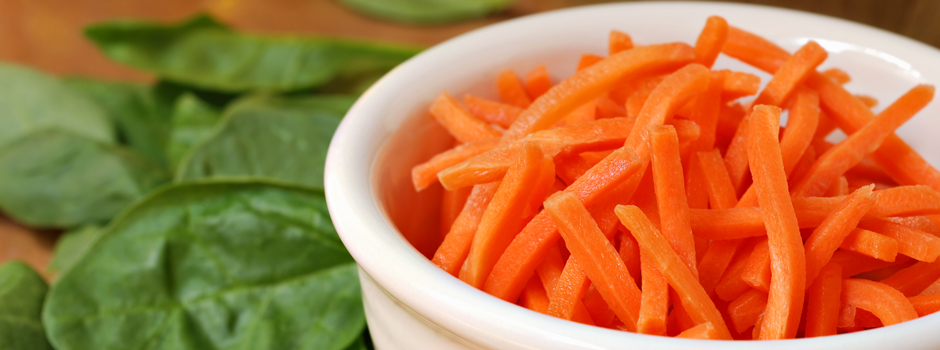 Freshly shredded carrots with spinach leaves