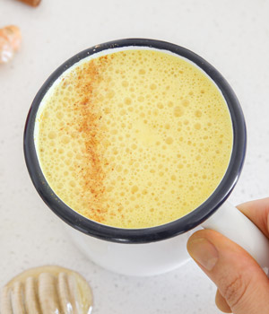 Holding Cup Of Turmeric Milk