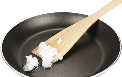 coconut oil in pan with wooden spoon