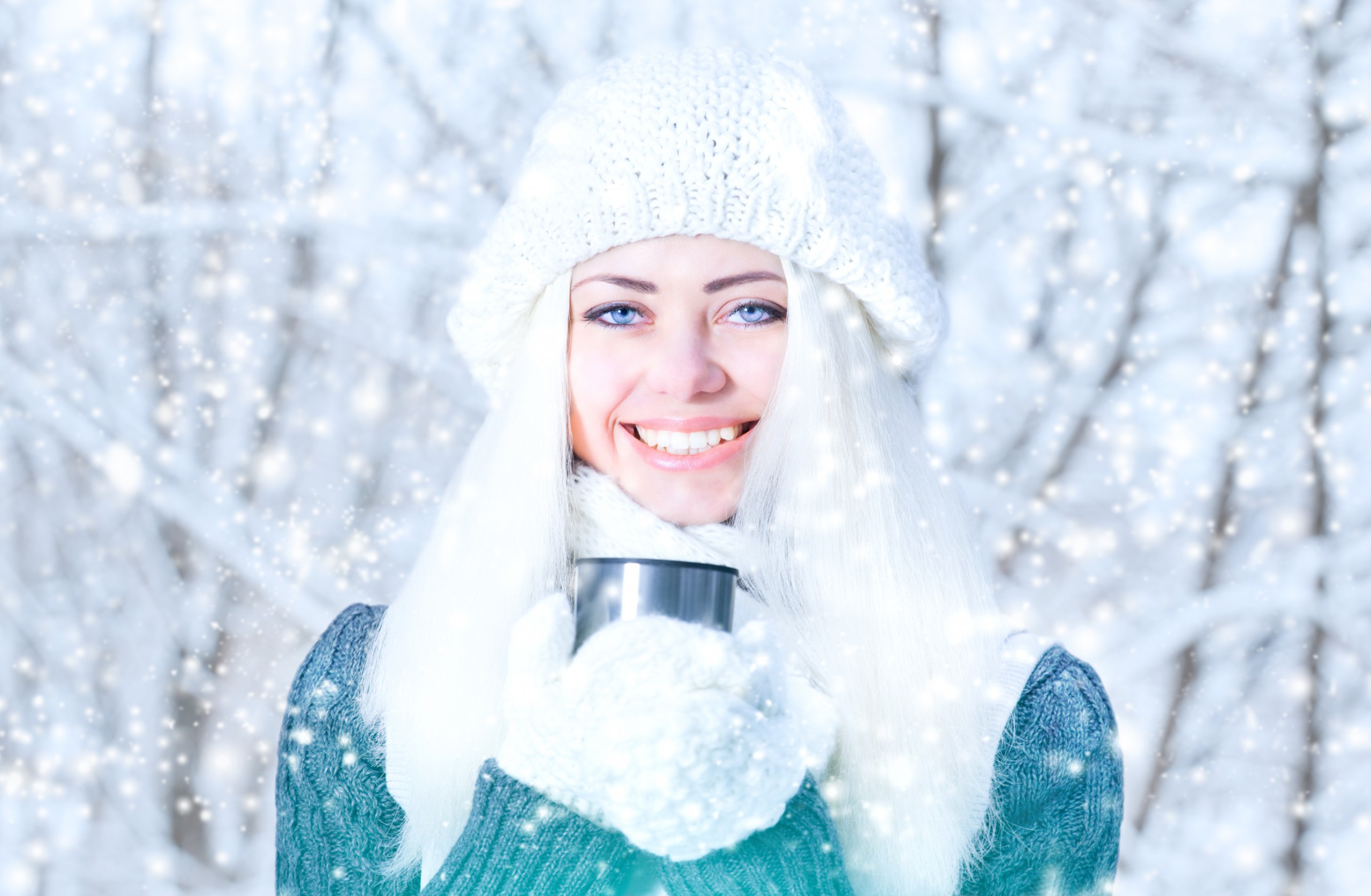 Winter girl is holding a cup with hot tea.